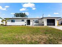 White house with black garage door, landscaping, and walkway at 240 Algiers Dr, Venice, FL 34293