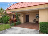 Exterior view of a tan house with a red tile roof and covered entryway at 3861 Catalina Dr, Bradenton, FL 34210