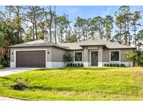 Newly constructed single-Gathering home with a 2-car garage and lush landscaping at 4497 N Salford Blvd, North Port, FL 34286