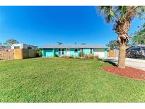 Charming teal home with a well-manicured lawn and a palm tree at 511 E 65Th Ave, Bradenton, FL 34203