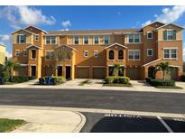 Tan three-story townhouses with attached garages and landscaping at 8908 White Sage Loop, Lakewood Ranch, FL 34202