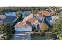 Aerial view of a single-Gathering home with a three-car garage and a lake view at 12031 Longview Lake Cir, Bradenton, FL 34211