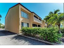 Tan colored building exterior with lush landscaping and palm trees at 129 Tyler Dr # 101, Sarasota, FL 34236