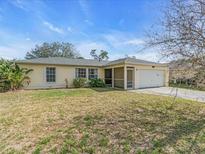Charming single-story home with a well-maintained lawn, a screened porch and an attached two car garage at 1382 Ronald St, North Port, FL 34286