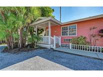 Pink cottage with white trim, front porch, and small yard at 1603 Gulf N Dr # 27, Bradenton Beach, FL 34217