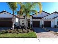 Exterior view of three-unit townhome building with two-car garages at 17322 Holly Well Ave, Wimauma, FL 33598