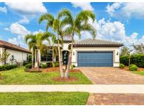 Single-story house with a blue garage door, landscaping, and palm trees at 17819 Eastbrook Ter, Lakewood Ranch, FL 34202