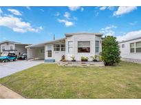 White single-wide mobile home with carport and landscaped lawn at 4953 Sea Island Ave, Sarasota, FL 34234