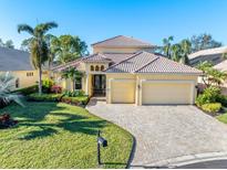Beautiful two-story home with tile roof, three car garage, and landscaped yard at 8808 Enclave Ct, Sarasota, FL 34238