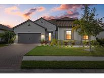 One-story home with stone accents, tile roof, and landscaped lawn at 2028 Woodleaf Hammock Ct, Bradenton, FL 34211