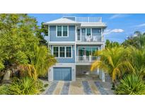 Two-story home with light blue siding, two balconies, and a two-car garage at 2213 Avenue B, Bradenton Beach, FL 34217