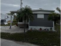 Mobile home exterior features a gray facade, covered patio, and landscaping at 2601 Gulf N Dr # S2, Bradenton Beach, FL 34217