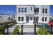 Modern light blue three-story home with a paved courtyard and black fence at 407 Gowdy Rd, Sarasota, FL 34237