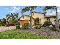 Single-story home with landscaped yard, orange garage door, and palm trees at 5552 Eagle Creek Rd, Sarasota, FL 34238