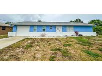 Charming blue house with white accents and a well-maintained lawn at 1109 Harbor Blvd, Port Charlotte, FL 33952