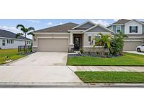 Two-story house with gray siding, stone accents, and a two-car garage at 11771 Richmond Trl, Parrish, FL 34219