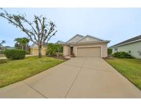 Single-story house with a two-car garage and well-manicured lawn at 1479 Blue Horizon Cir, Bradenton, FL 34208