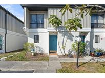 Updated condo exterior with a teal door and well-manicured landscaping at 4001 Beneva Rd # 208, Sarasota, FL 34233