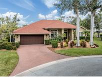 Attractive single-story home with a red tile roof, landscaped yard, and brick driveway at 4539 Longspur Ln, Sarasota, FL 34238