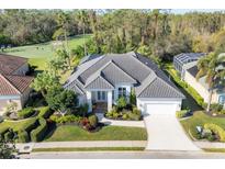 Luxury home with tile roof, landscaping, and driveway, located on a golf course at 4838 88Th E St, Bradenton, FL 34211