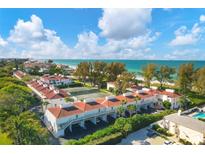 Aerial view of condo community near beach, featuring tennis courts and pool at 5055 Gulf Of Mexico Dr # 424, Longboat Key, FL 34228