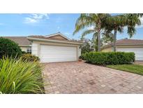 Well-maintained house with a white garage door and a brick driveway at 5890 Guarino Dr, Sarasota, FL 34238