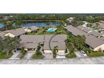 Aerial view of a community with houses, lake, and pool at 5911 Doral Dr, Sarasota, FL 34243