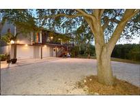 Two-story home with attached garage and expansive driveway, nestled under a large tree at 631 43Rd Street W Blvd, Palmetto, FL 34221