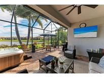 Relaxing screened lanai with hot tub, outdoor seating, and lake view at 6579 Willowshire Way, Bradenton, FL 34212