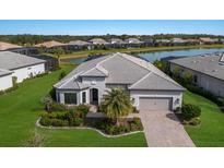 Aerial view of a single-Gathering home with a lake view and lush landscaping at 712 Sigsbee Loop, Sarasota, FL 34240