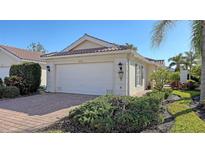 Single-story home with attached garage and landscaped front yard at 7575 Quinto Dr, Sarasota, FL 34238