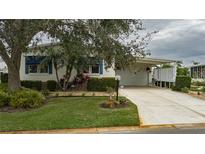 Well-maintained manufactured home with carport and landscaped yard at 8414 Imperial Cir, Palmetto, FL 34221