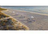 Relaxing beach with lounge chairs and umbrellas at 1465 Gulf Of Mexico Dr # 402, Longboat Key, FL 34228