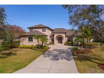 Two-story house with light brown exterior, a large driveway, and lush landscaping at 14901 17Th E Ave, Bradenton, FL 34212