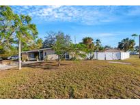 Ranch style home with large yard, mature trees, and white fence at 2416 Amherst Ave, Bradenton, FL 34207