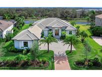 Luxury home with tile roof, driveway, and lush landscaping at 3354 Founders Club Dr, Sarasota, FL 34240