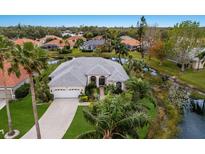 Single-Gathering home with tile roof, landscaping, and driveway; located on a canal at 4452 Mcintosh Lake Ave, Sarasota, FL 34233