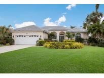 Single-story home with tile roof, attached garage, and lush landscaping at 4452 Mcintosh Lake Ave, Sarasota, FL 34233