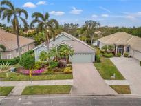 Single-story home with landscaped yard, brick driveway, and two-car garage at 6234 Sturbridge Ct, Sarasota, FL 34238