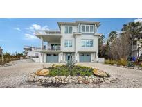 Two-story home with gray double garage doors and landscaped front yard at 625 Jackson Way, Longboat Key, FL 34228