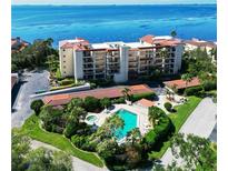 Aerial view of waterfront condo building with pool and lush landscaping at 6440 Mourning Dove Dr # 101, Bradenton, FL 34210