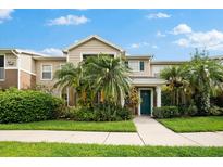 Two-story townhome with a green door and lush landscaping at 7417 Vista Way # 106, Bradenton, FL 34202