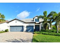 Two-story house with gray-blue garage doors and nicely landscaped lawn at 8052 Grande Shores Dr, Sarasota, FL 34240