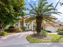 Beautiful two-story home with palm trees and a brick driveway at 12317 Baypointe Ter, Cortez, FL 34215