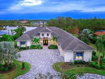 Luxury home with lake views, spacious driveway, and lush landscaping at 19458 Beacon Park Pl, Lakewood Ranch, FL 34202