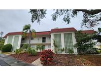 Two-story condo building with red tile roofs and lush landscaping at 3606 Beneva Rd # 502, Sarasota, FL 34232