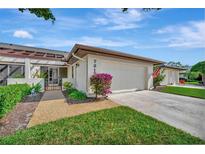 Front view of a light-colored house with a garage and well-maintained landscaping at 7317 Ballantrae Pl # 27B, Sarasota, FL 34238