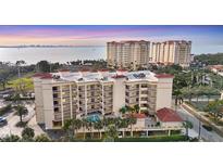 Aerial view of a waterfront condo building with pool and parking at 1188 N Tamiami Trl # 203, Sarasota, FL 34236