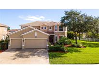 Two-story house with a tan exterior, landscaped lawn, and two-car garage at 1269 Western Pine Cir, Sarasota, FL 34240