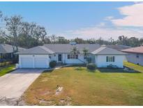 White single-story home with a two-car garage and well-maintained lawn at 2425 Riverview Blvd, Bradenton, FL 34205